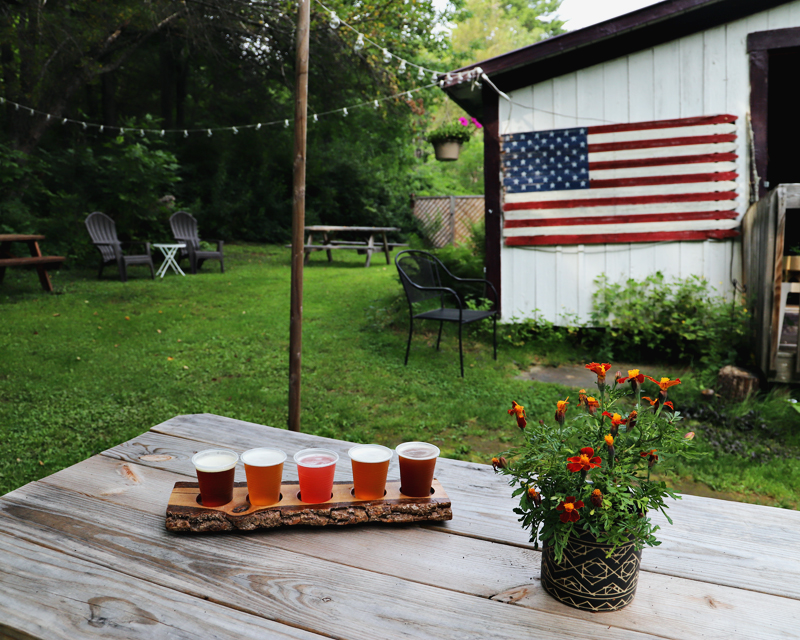 Woodman's Brewery in Bristol NH outdoor seating with tasting sampler